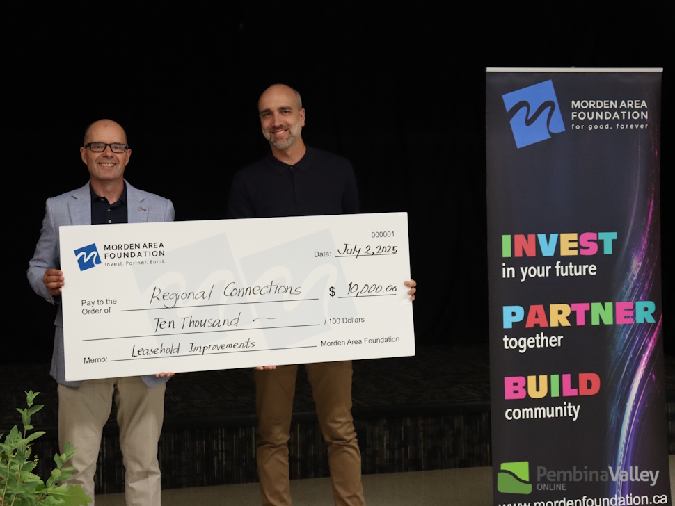 people stand behind a large cheque 