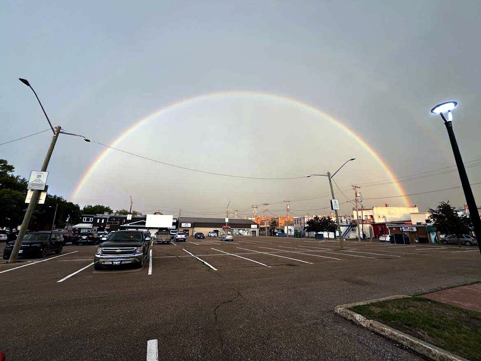 Double rainbow stretching across the sky above downtown Portage la Prairie, looking east.