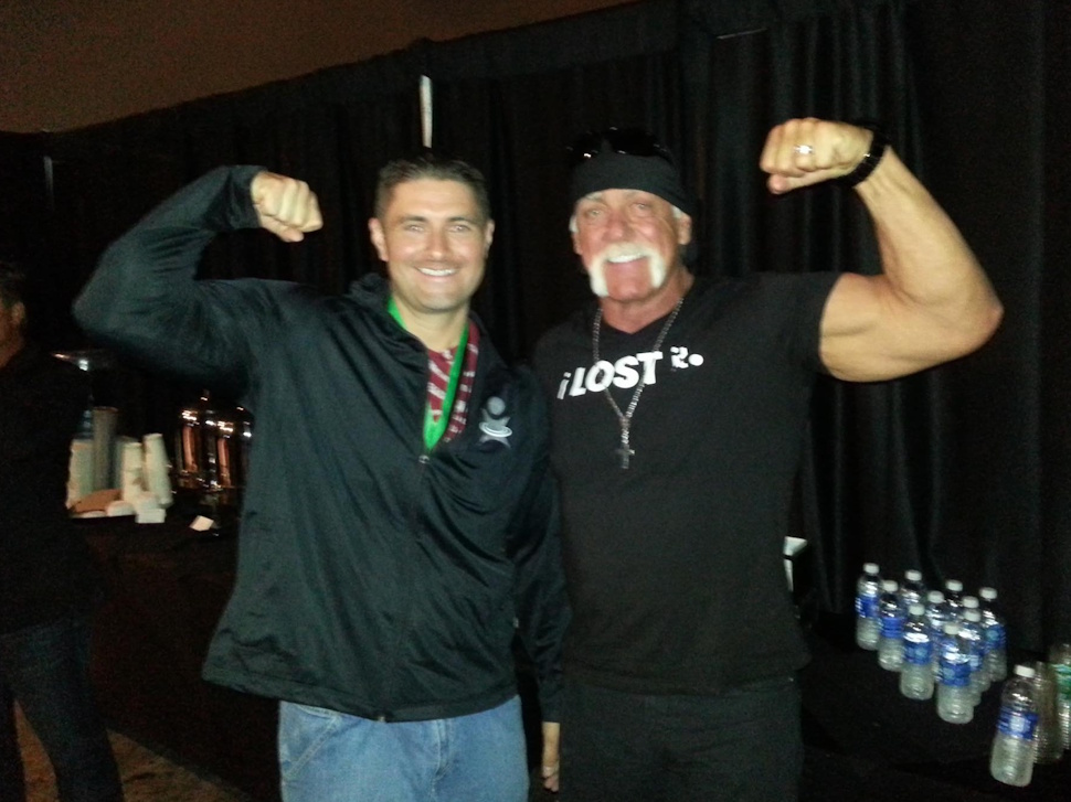 Ryan Espey flexes his muscles alongside wrestling legend Hulk Hogan in an old photo.