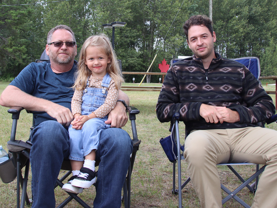 Family sitting on lawn chairs 