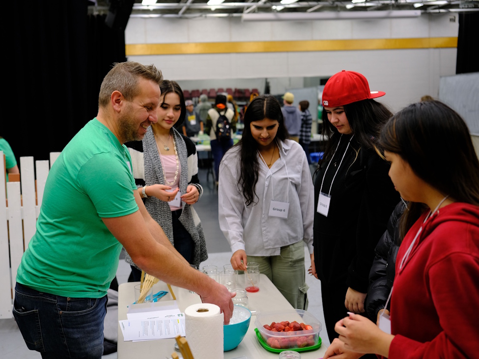 a man demonstrating something about food to students at an Ag Fair