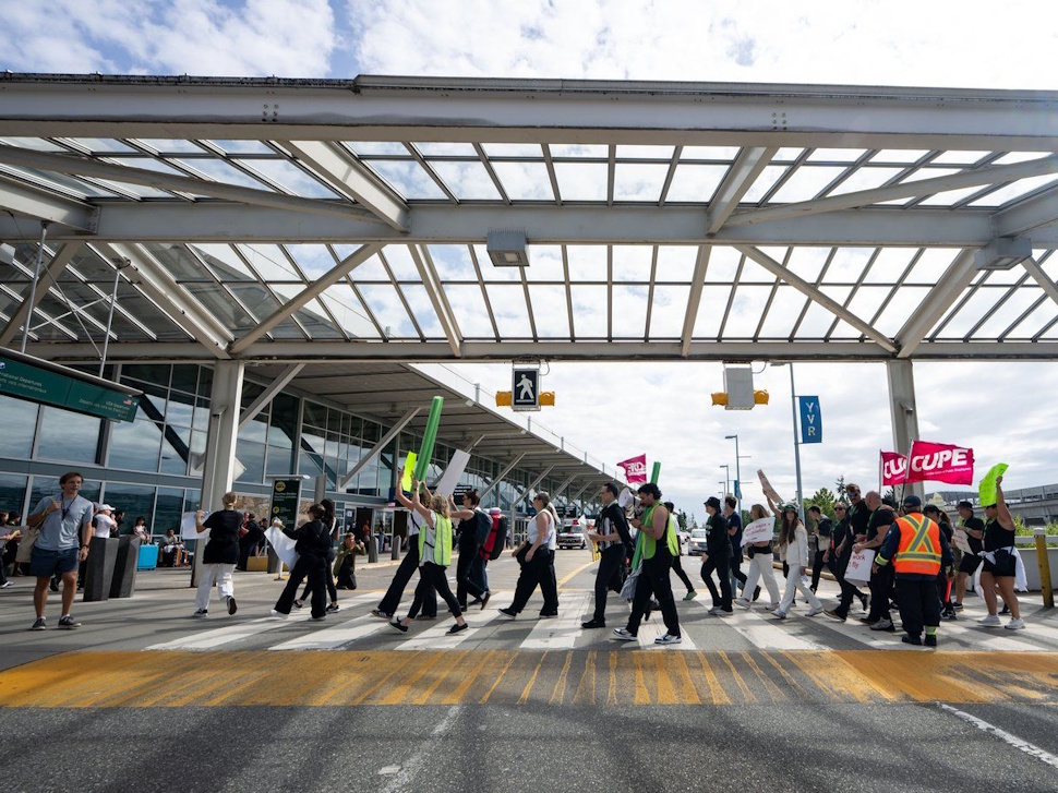Picketers march around the departures level at the Vancouver International Airport in Richmond, B.C., on Sunday, Aug. 17, 2025. Air Canada made the call to halt a return to operation as flight attendants continue to strike. THE CANADIAN PRESS/Ethan Cairns