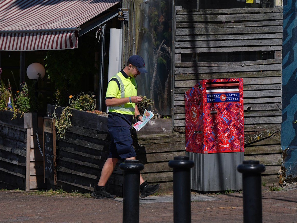 Unionized workers at Canada Post are entering their final day to vote on the Crown corporation's latest contract offer. A Canada Post employee prepares to check a street letter box while delivering mail, in White Rock, B.C., on Monday, July 28, 2025. The Canadian Union of Postal Workers is urging they reject the proposal. THE CANADIAN PRESS/Darryl Dyck