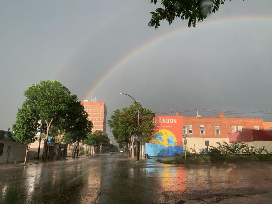A mural on a building after a rain with the rainbow above the building