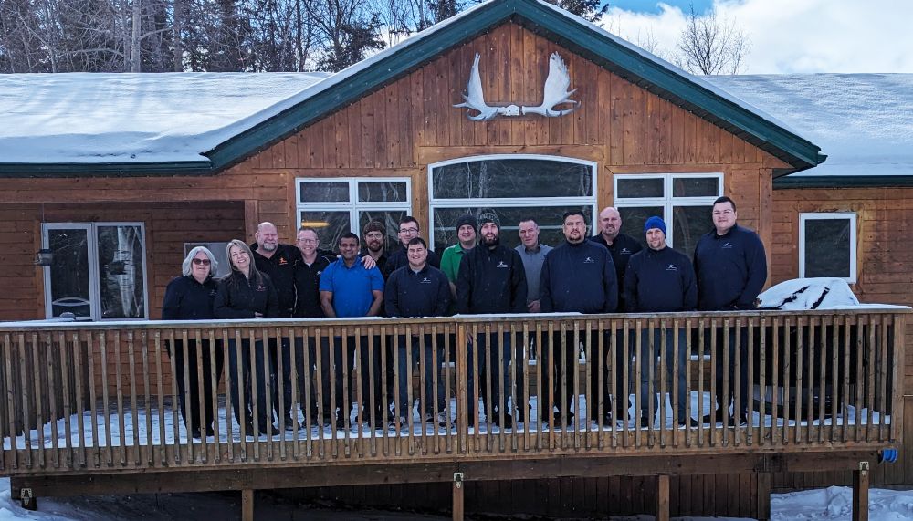 a group of people standing on a deck in front of a wooden builden