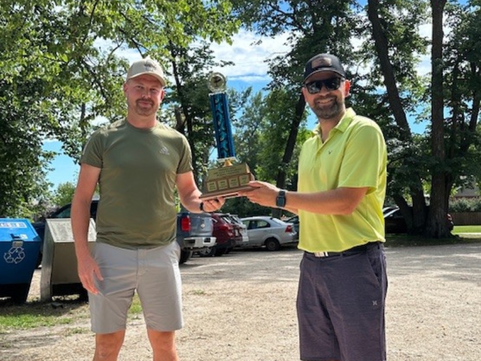 Cody Buhler (right) hand the trophy off to Marshall Toews (left) after the Portage Open. Photo credit: Submitted by Cody Buhler)