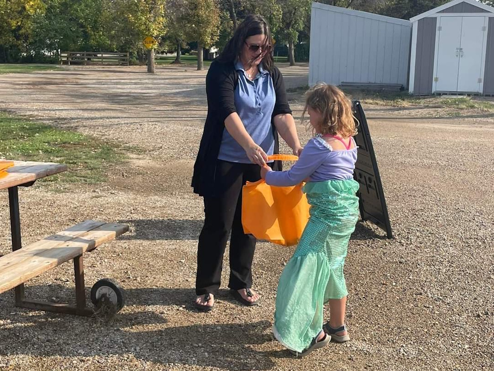 a girl dressed up trick or treating in the summer time