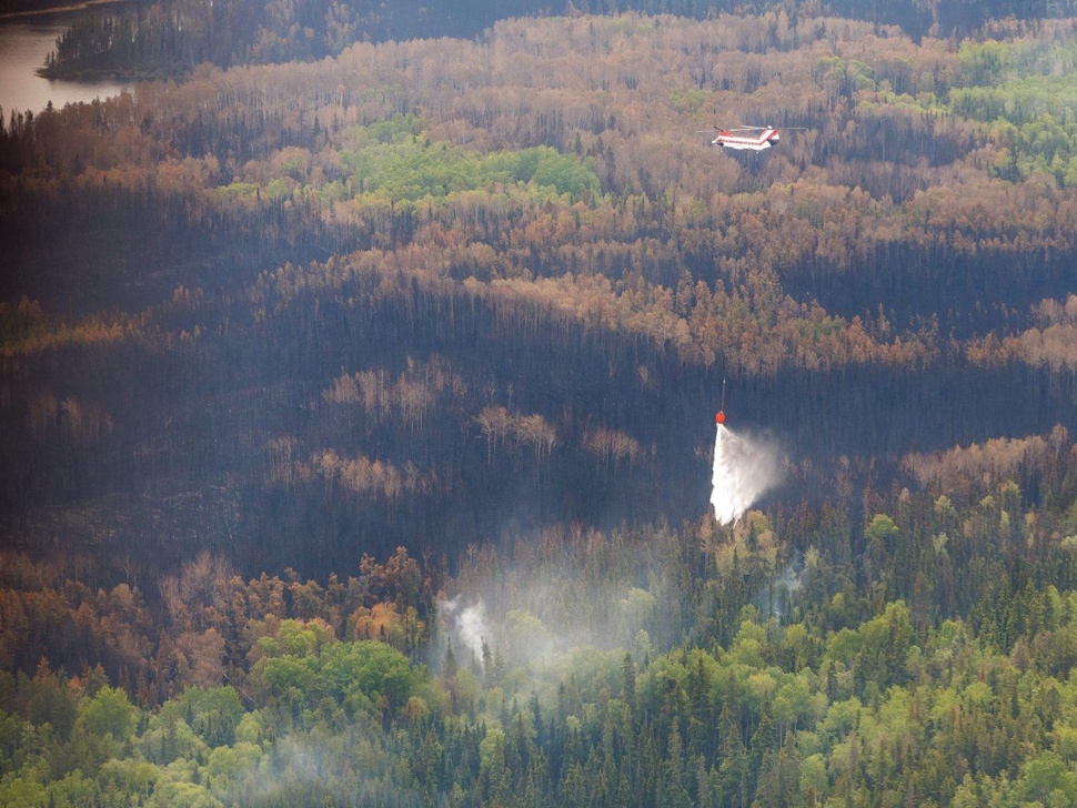 A helicopter crew works on a wildfire in northern Manitoba during a helicopter tour in the surrounding area of Flin Flon, Man. on Thursday, June 12, 2025. THE CANADIAN PRESS/Mike Deal