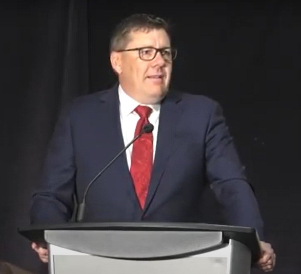 Premier Scott Moe in a dark suit, white shirt and a red tie