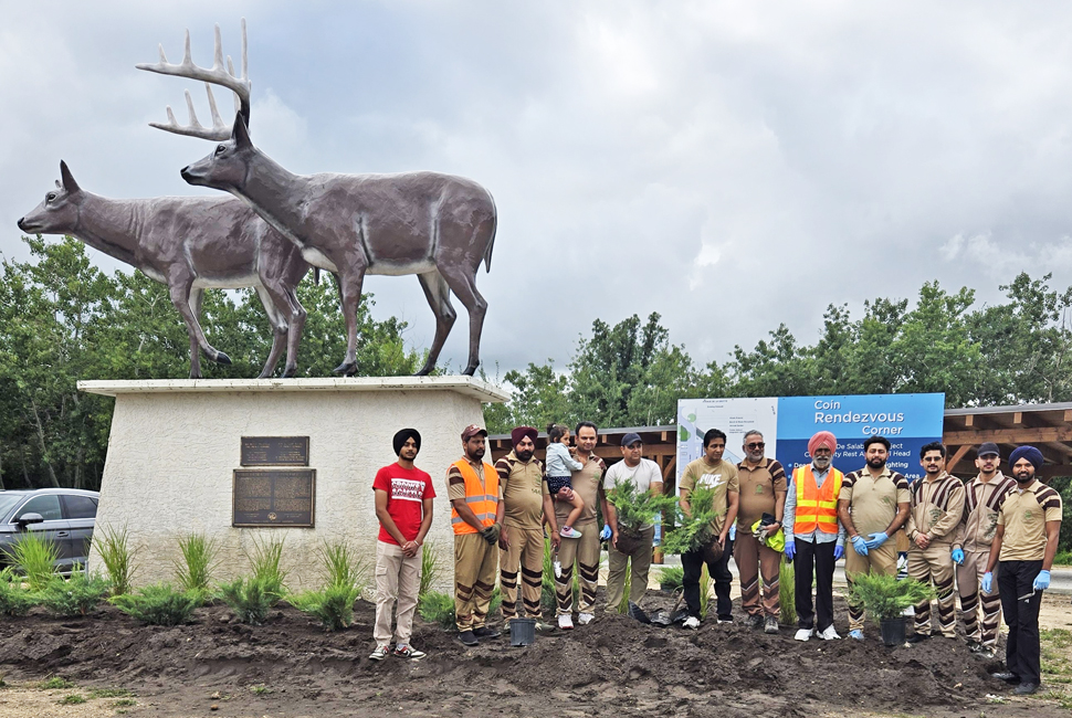 Volunteers stand in front of deer statue in St. Malo