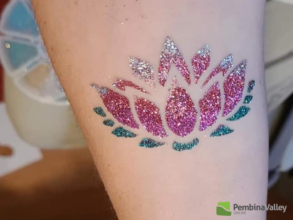 a glitter tattoo of a flower on an arm