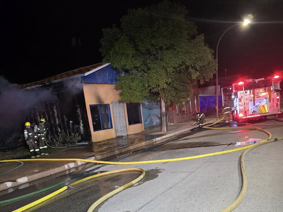 a fire truck at a building in the night and firefighters are fighting a fire