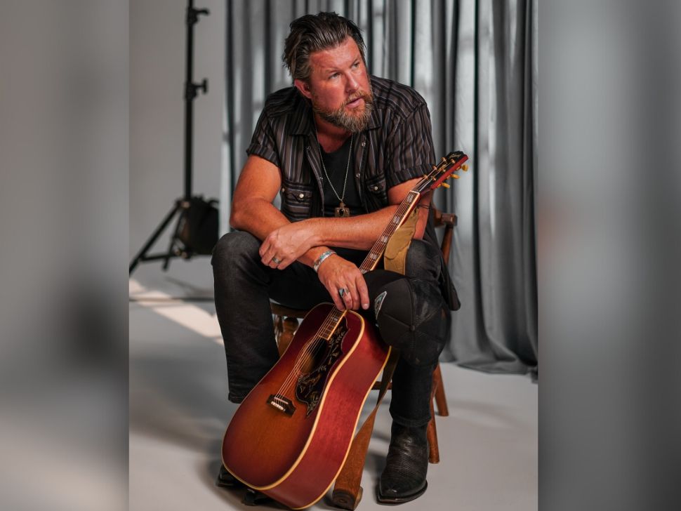 Zach Williams sitting in a studio with his acoustic guitar in front of him. (Zach Williams/Facebook)