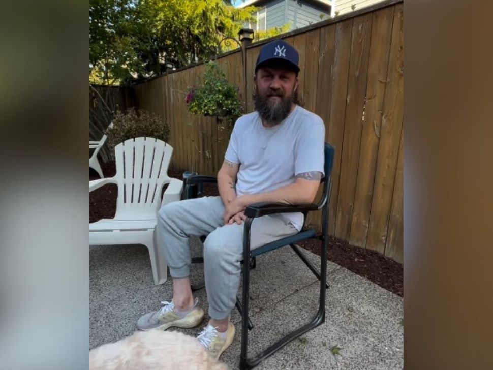 James Mead sitting in a lawn chair in his backyard, giving a video update after he suffered from a stroke. 
