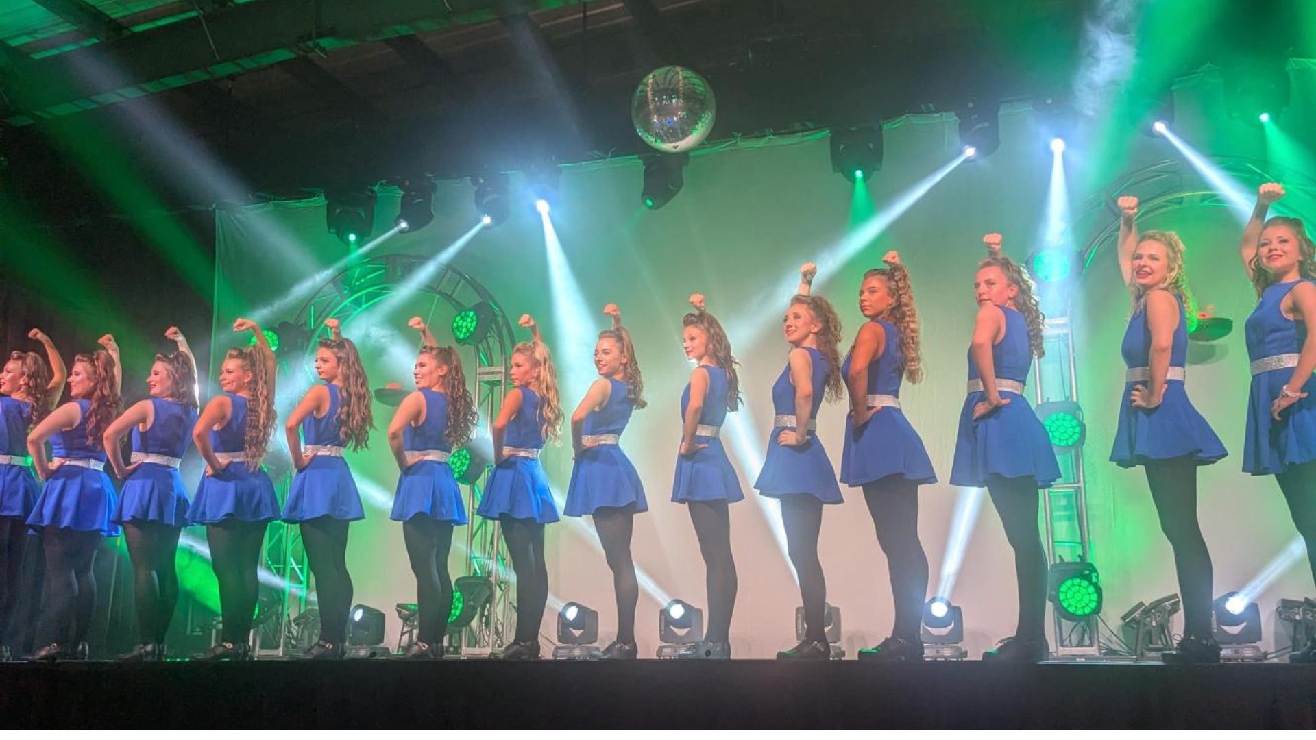 Over 10 Irish Dancers posing for a picture at Folklorama in blue costumes and black nights