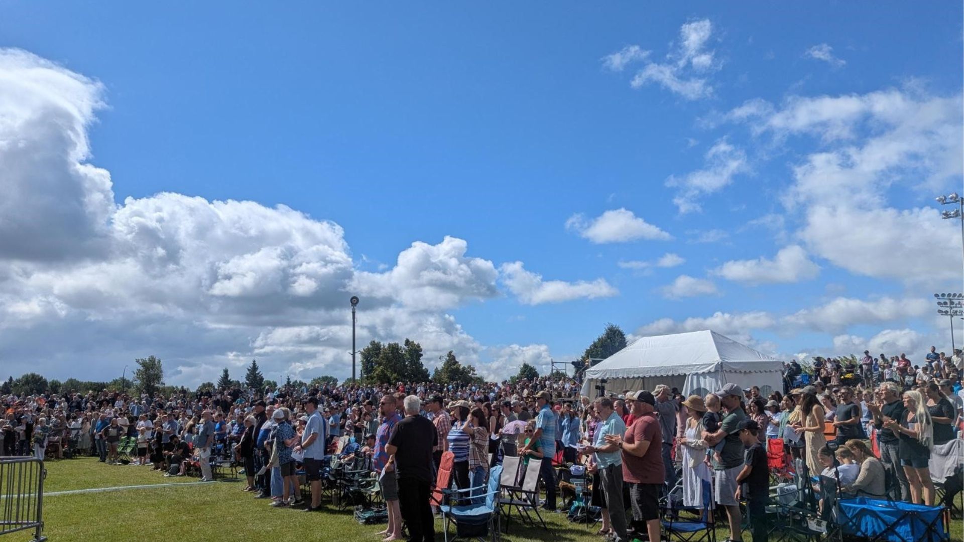 Over 400 people in a crowd for a Sunday morning community church service in the park