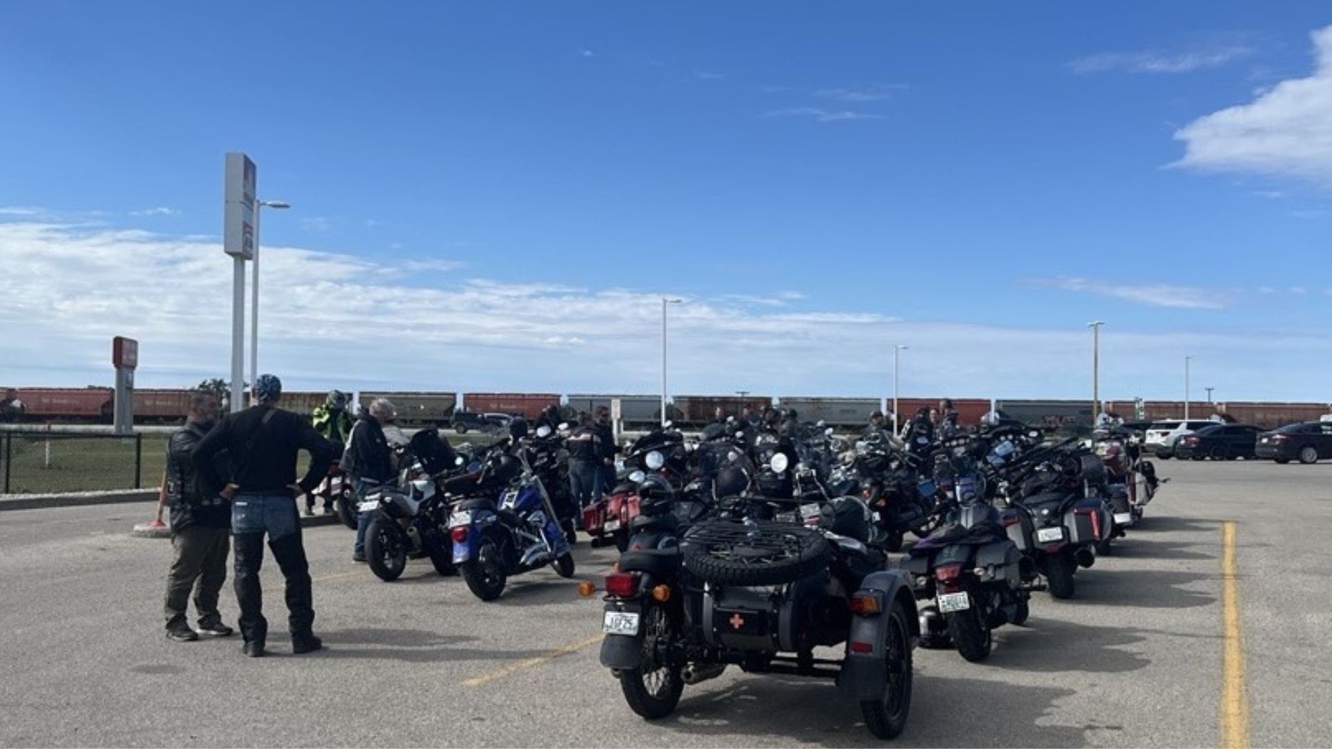 A large gathering of motorcyclists in a parking lot