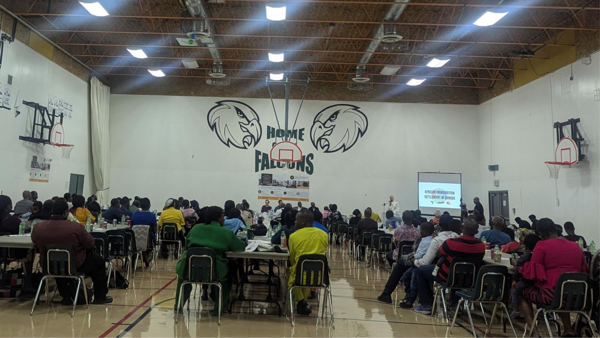 People in a large gymnasium at a seminar
