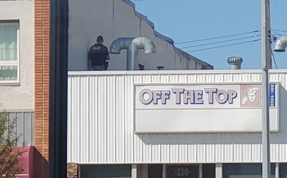 Submitted photo [police on roof on business on Saskatchewan Avenue in Portage la Prairie 