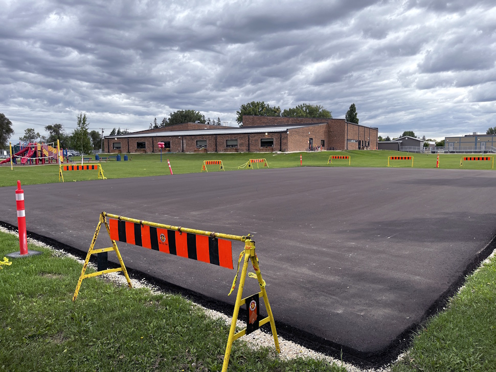 Newly laid asphalt at Crescent View School basketball and pickleball court under construction.