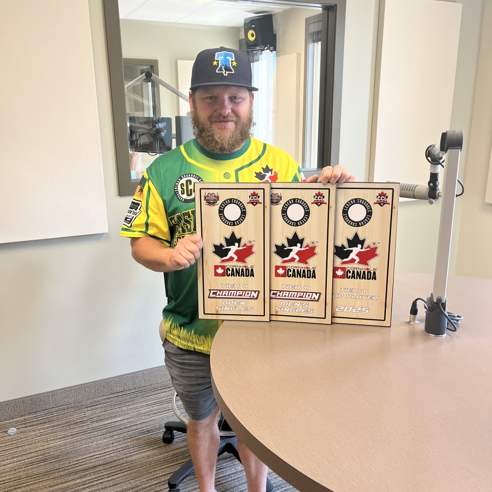 devin furgason holding 3 cornhole medals