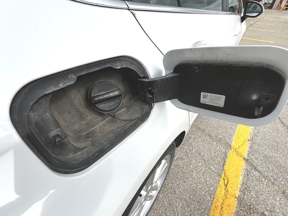 Close-up of a car’s gas cap with the fuel filler opening visible.