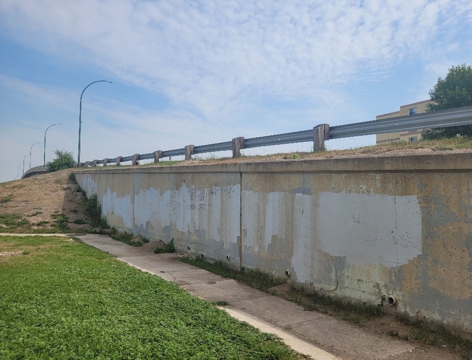 Graffiti on a wall partially painted over by Portage green team.