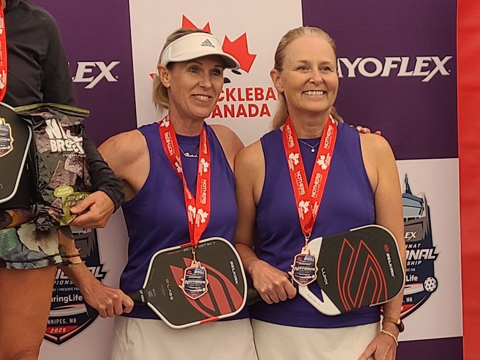 Sue Davidson and Robin Chase stand on the podium holding their medals after winning bronze in women’s doubles at the 2025 National Pickleball Championship in Winnipeg.