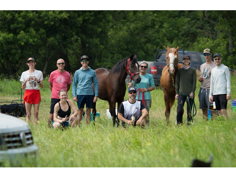 a group shot of horses and riders and runners