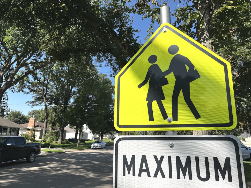 School zone speed limit sign in Portage la Prairie showing 30 km/h, enforced year-round at all hours.