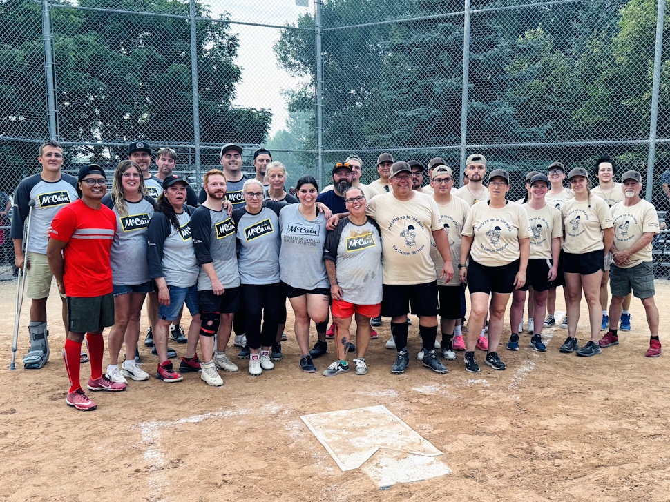 Players from both McCain and Simplot teams pose together behind home plate at Rotary Republic Park.