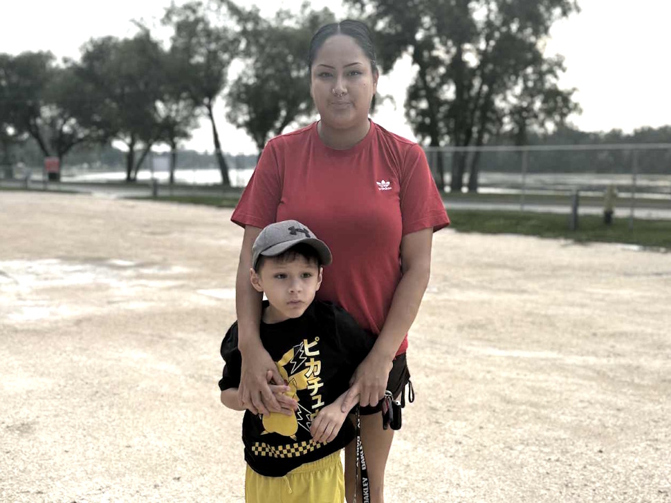Shaelen Gabriel smiling while holding her son Kashtyn, aged six, outdoors at Splash Island in Portage la Prairie.