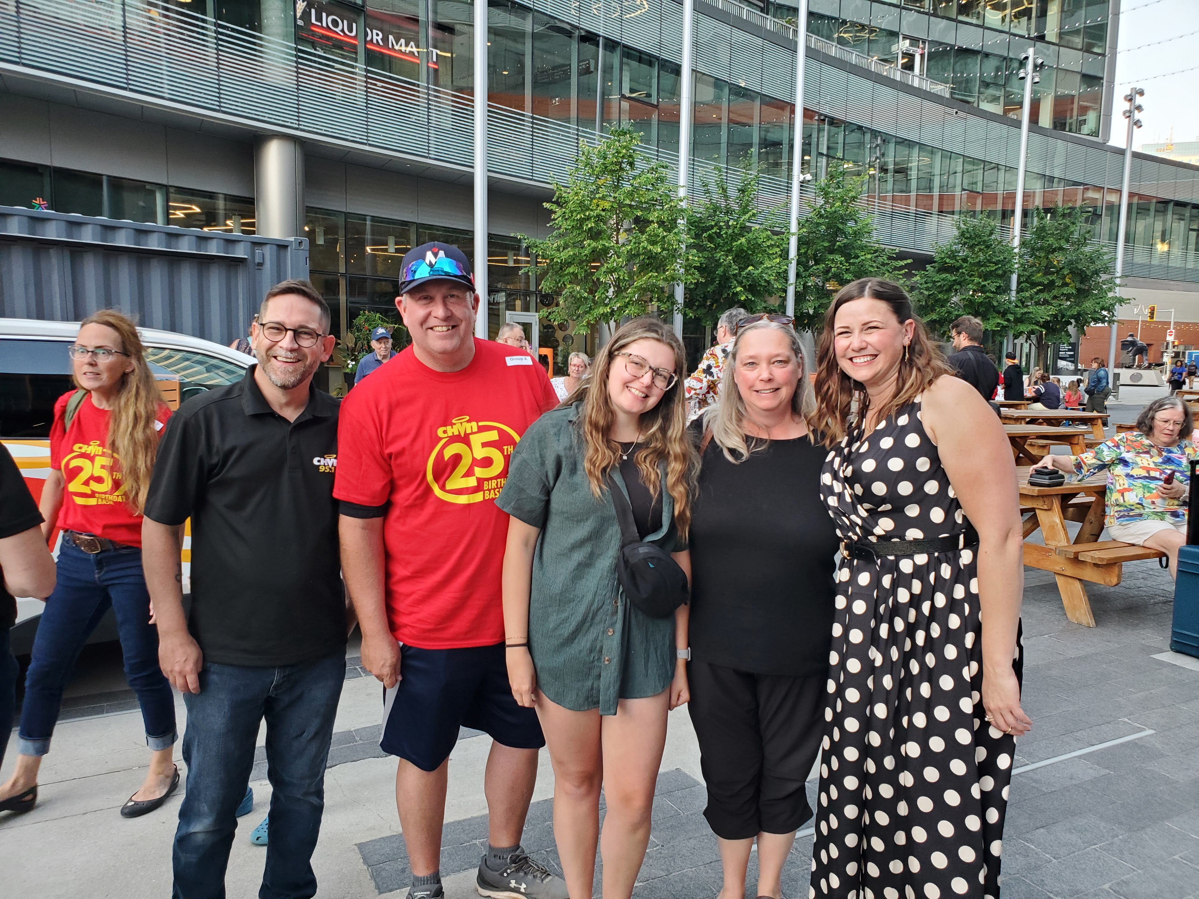A MOTHER, FATHER, AND YOUNG ADULT DAUGHTER POSE FOR A PHOTO WITH MIKE THOM AND SYLVIA ST CYR