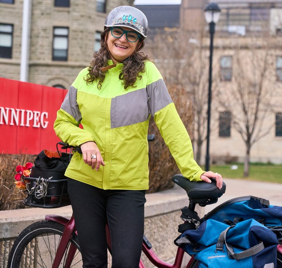 Patty Wiens posing with her bike outside the University of Winnipeg. 