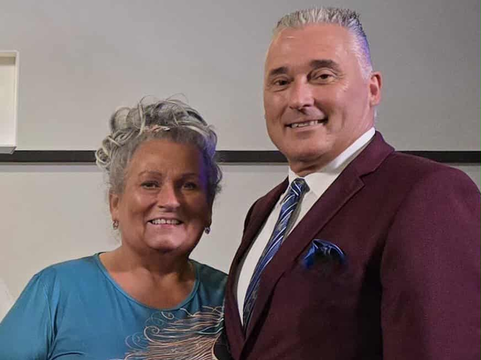 a middle aged couple smiling at the camera