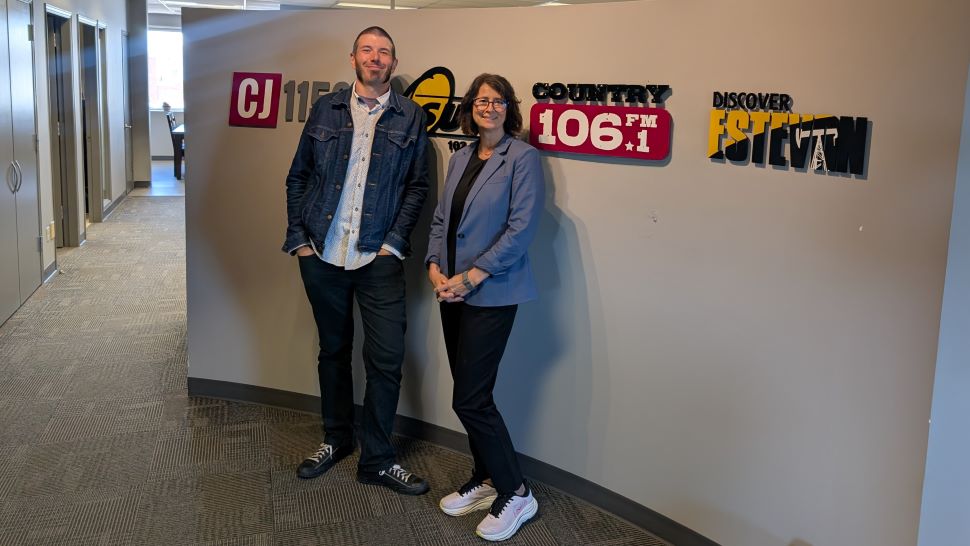 DAN AND TANIA ANDRIST IN FRONT OF SIGNS 