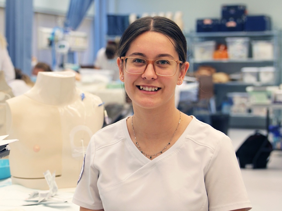 a young female nurse smiling into the camera
