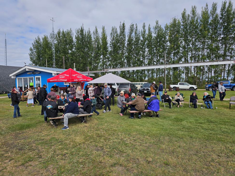 a group of people eating outside at a flying club green space