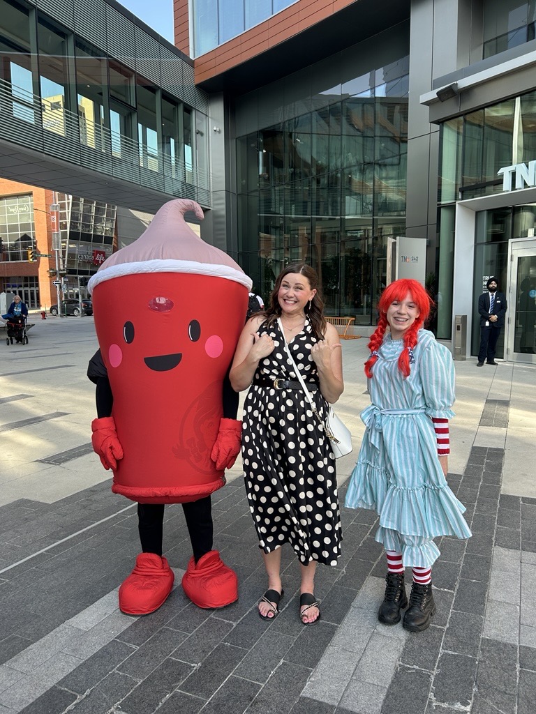 Sylvia St. Cyr stands beside mascots from Wendy's restaurants