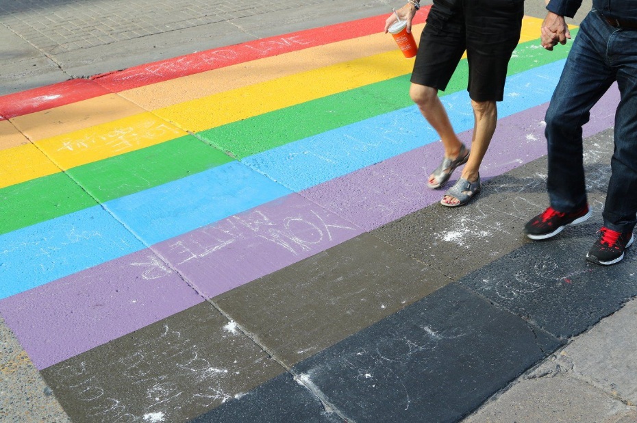 People walk on a Pride flag crosswalk in Calgary on Sunday, Aug. 18, 2019. THE CANADIAN PRESS/Dave Chidley
