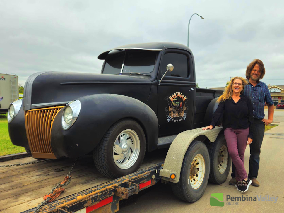 two people stand by a vintage truck