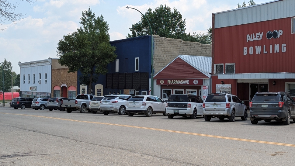 A main street lined with cars on a sunny day