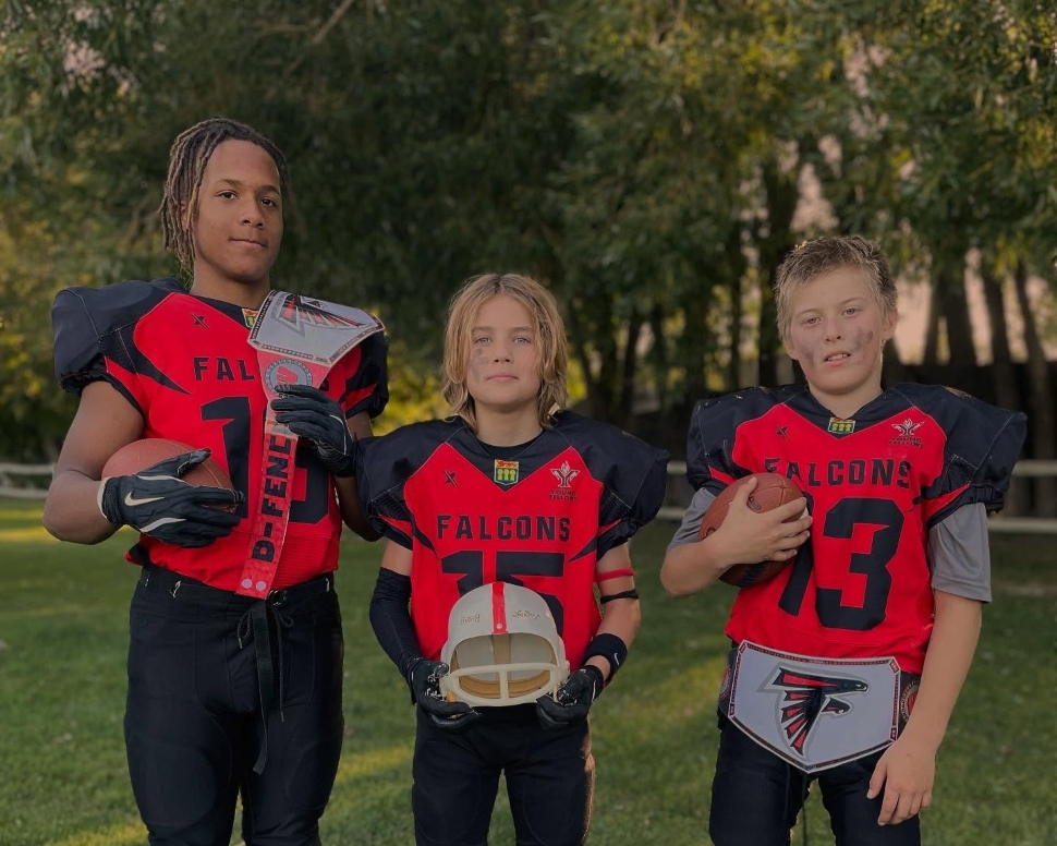 Three football players in red and black jerseys
