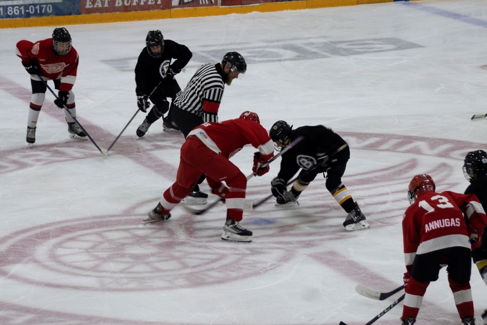 A hockey faceoff between a team in red and a team in black