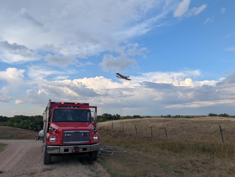 An airplane flying over a fire truck