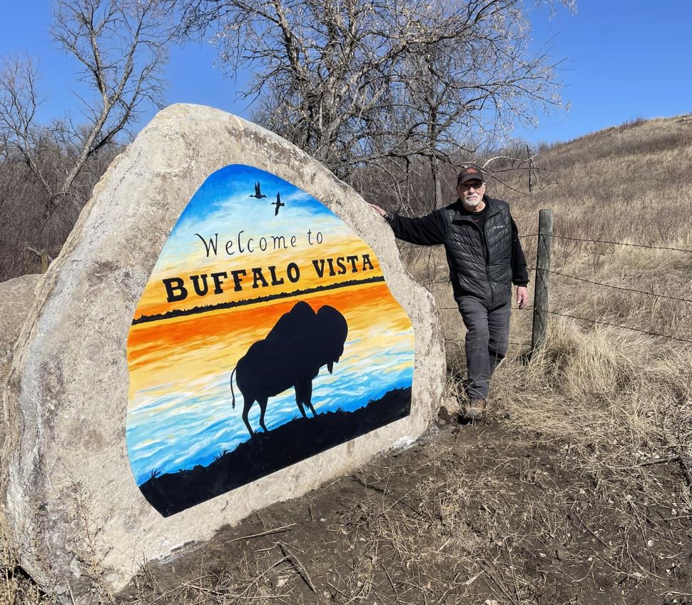 Grant McLaughlin stands next to his freshly completed mural