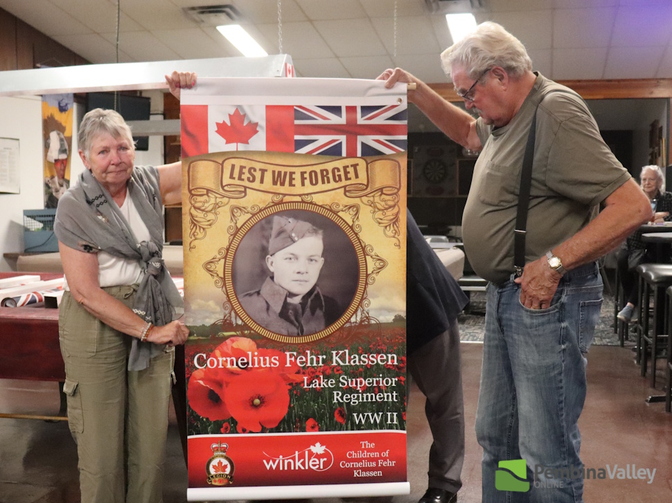 two people stand with a banner