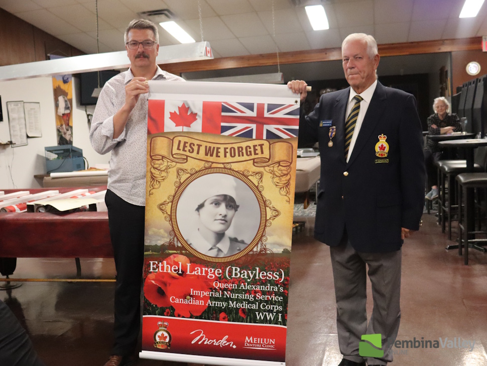 two people stand with a banner