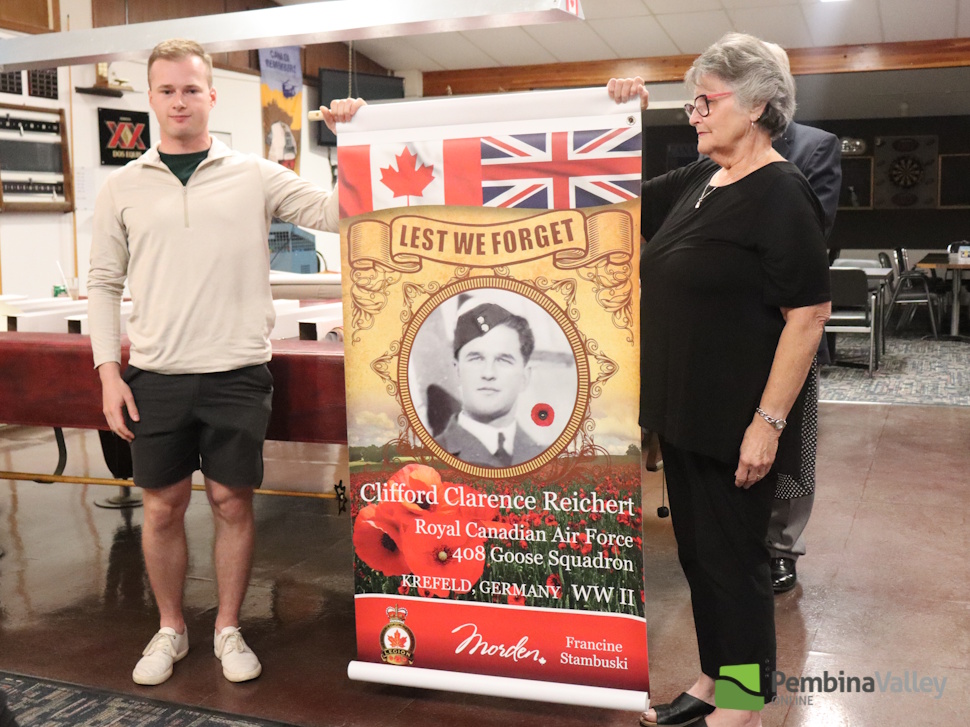 two people stand with a banner