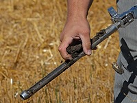 hand taking sample of soil out of a soil sampling rod 